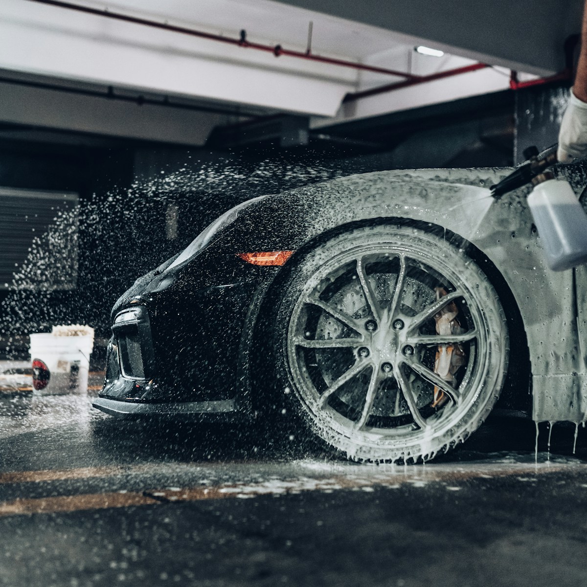 Exterior foam wash on a black vehicle wheel